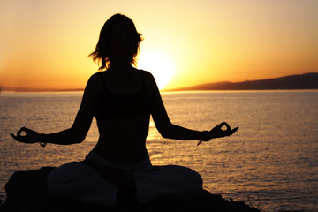 beauty girl in lotus pose on sunrise beach