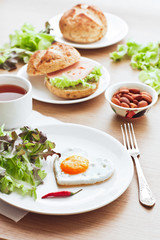 Fried egg on heart-shaped toast with salad for Valentine's Day