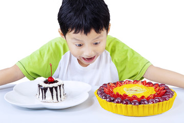 Excited boy looking at colorful desserts