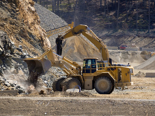 Excavator shovel digging in a gravel pit