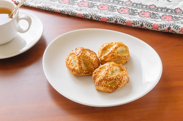 Three Puffs with Chicken, Mushrooms and Sesame in a white porcelain plate