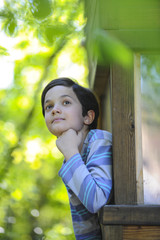 Enfant observant la nature dans sa cabane