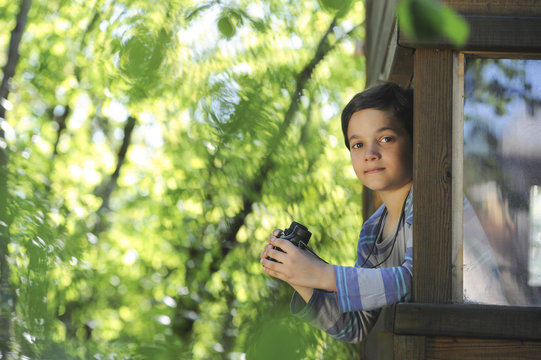 Enfant observant la nature dans sa cabane