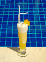 Pineapple juice with pool in the background
