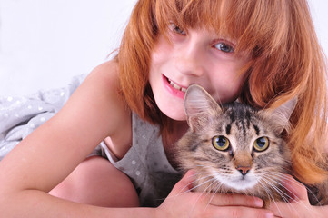 little girl hugging her cat