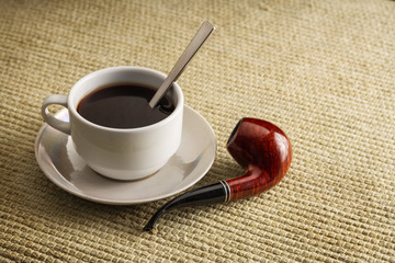 A cup of black coffee with a pipe in high resolution