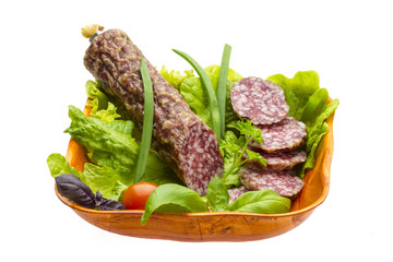 Ripe salami with salad, basil, onion and tomato