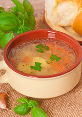 Chicken soup in the brown ceramic bowl