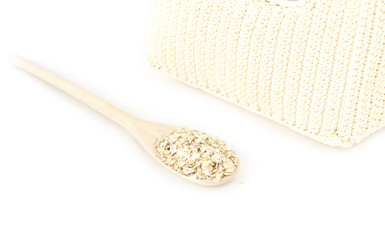 Oatmeal in the wooden spoon on white background