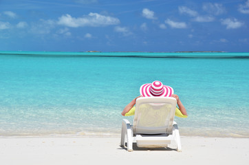 Girl in a striped hat on the beach of Exuma, Bahamas
