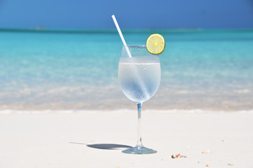 Glass of water on the tropical beach
