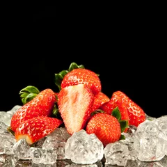 Foto op Plexiglas aardbei op zwarte achtergrond. aardbeien met ijsblokjes erop © EwaStudio