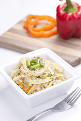Pasta with peppers in background.