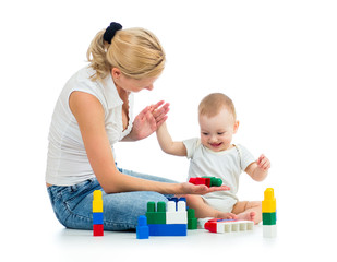 baby boy and mother playing together with construction set toy