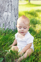 little boy sitting on the grass