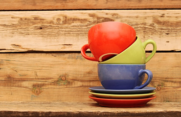 Colorful coffee mugs over an grunge wooden background