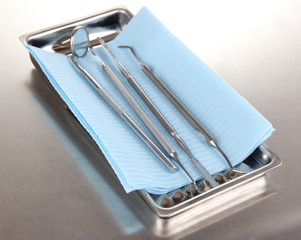 Dentist tools on grey table close-up