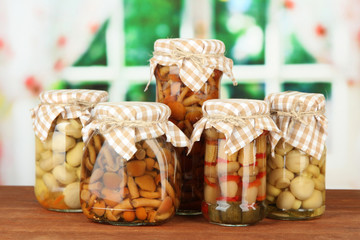 Delicious marinated mushrooms in glass jars,