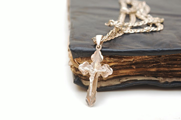 Religion. A cross with a chain against a old book