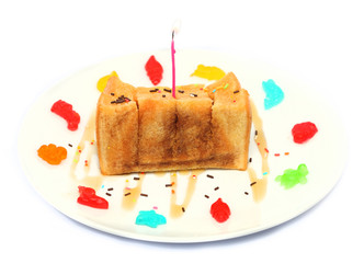 Bread topped with honey and a birthday candle isolated on white