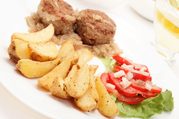 Meatballs with stewed onion and fried potato wedges