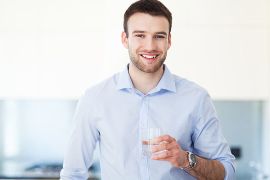 Man In Kitchen With Glass Of Water