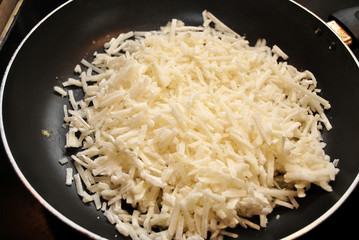 Frozen Shredded Potatoes in a Fry Pan