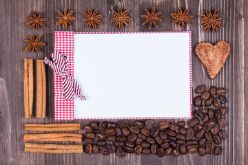 Notebook, coffee beans, cinnamon, star anise on wood background