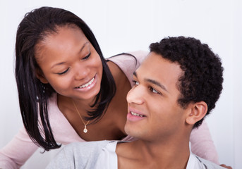 Woman Whispering To Boyfriend's Ear