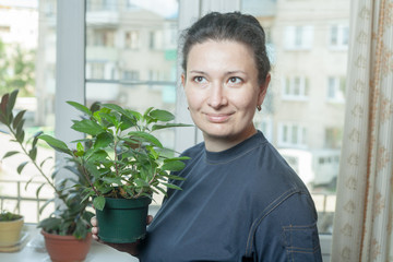 Latina woman holding flower pot  indoor