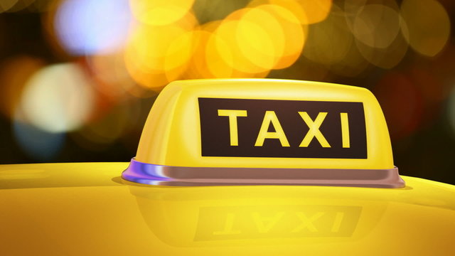 Yellow taxi sign on car