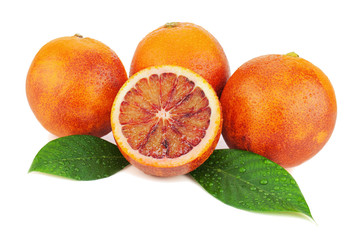 Ripe red blood oranges with cut and green leaves isolated on whi