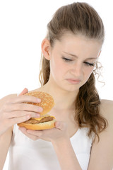 Jugendliche schaut angewidert in Cheeseburger