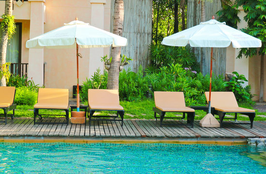 Beach chairs and umbrella side swimming pool