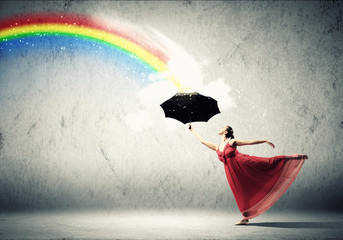 Ballet dancer in flying silk dress with umbrella