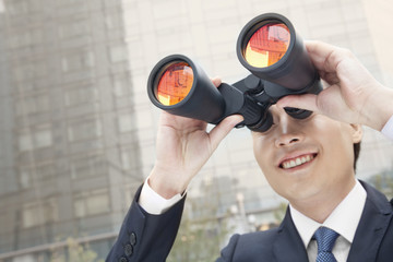 Fototapeta na wymiar Smiling Businessman Using Binoculars, Reflection