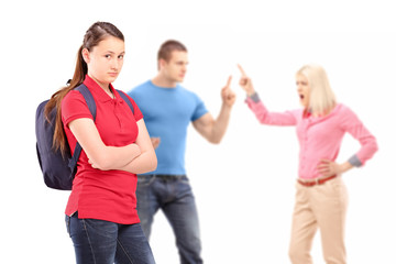 Deppressed teenager looking at camera with mother and father arg