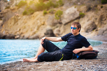 Fototapeta na wymiar Tourist is resting on the sea coast