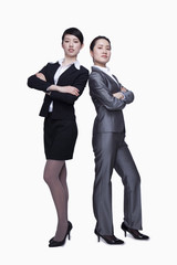 Businesswomen standing back to back and looking at camera, portrait