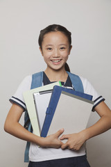 Obraz premium Girl smiling and holding bunch of notebooks and digital tablet, Studio