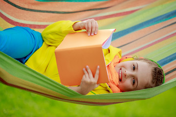 Young girl in headphones reading a book