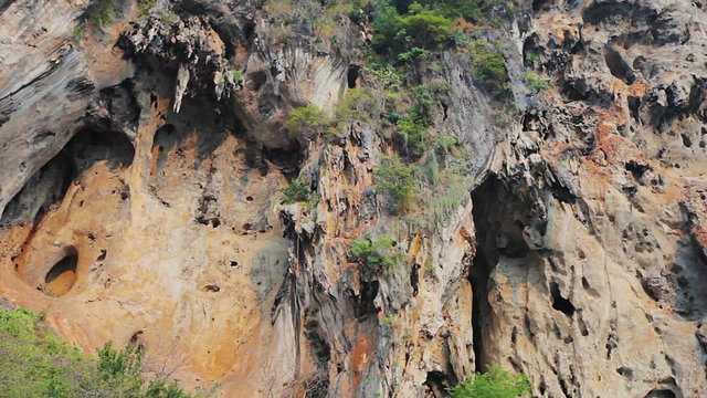 Panoramic view on high limestone rock with stalactites and caves