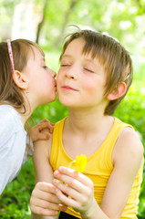 Young girl gives her brother a kiss on the cheek