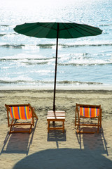 Beach chairs and umbrella on beach.