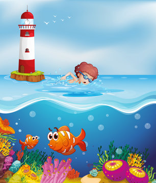 A boy swimming with fishes and corals at the beach