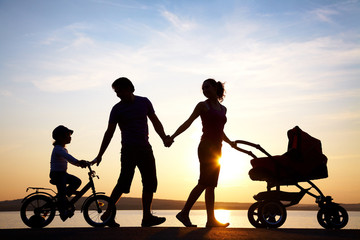 Fototapeta na wymiar happy family walking on sunset