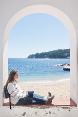 Woman resting under an arch in Calella de Palafrugell