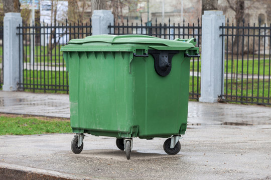Green recycling container on the street of city