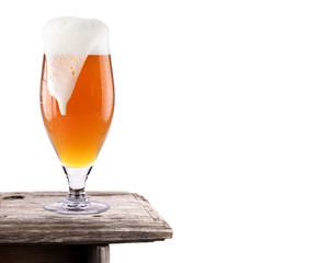Frosty fresh beer  with foam isolated  on wooden table
