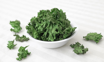 Kale Chips -  A bowl of home-made kale chips sitting on a table.